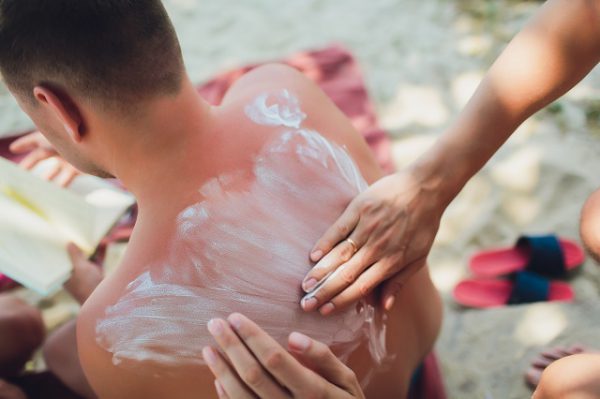 Krem z witaminą e łagodzi dolegliwości poparzenia słonecznego na plecach mężczyzny