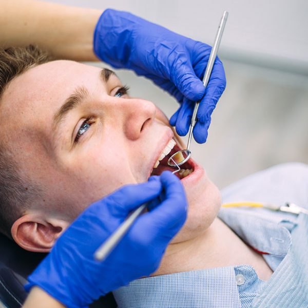 Mężczyzna podczas leczenia próchnicy w gabinecie stomatologicznym