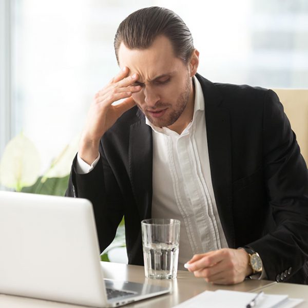 Objawy klasterowego bólu głowy towarzyszą mężczyźnie podczas pracy na komputerze
