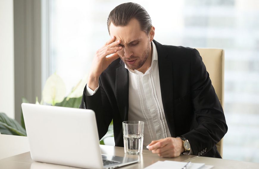Objawy klasterowego bólu głowy towarzyszą mężczyźnie podczas pracy na komputerze